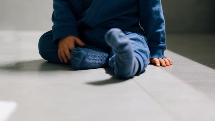 Vauva istuu kylpyhuoneen laattalattialla