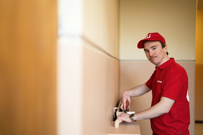 Asentaja kiinnittää termostaattia lämpöpatteriin