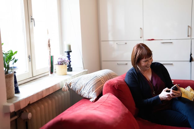 Woman sitting on a sofa and using  a mobile phone